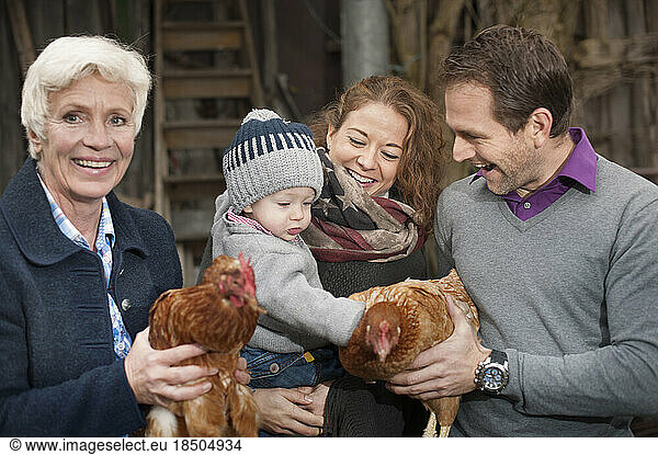 Family with chicken birds standing in poultry farm  Bavaria  Germany