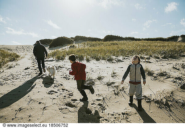 Family with dog on sand dune