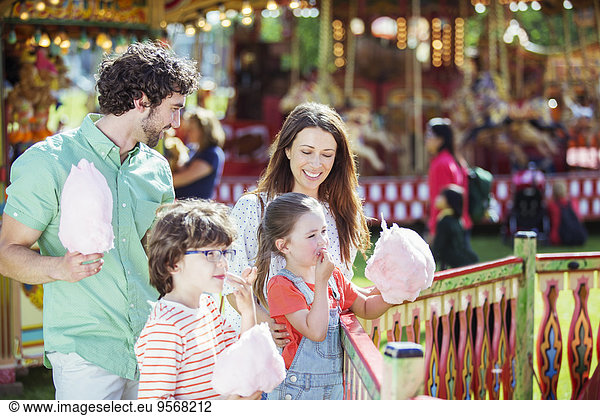 Family with pink candy floss in amusement park