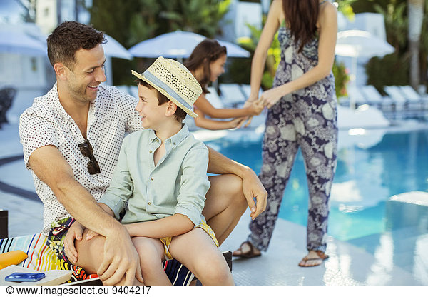 Family with two children enjoying themselves by swimming pool