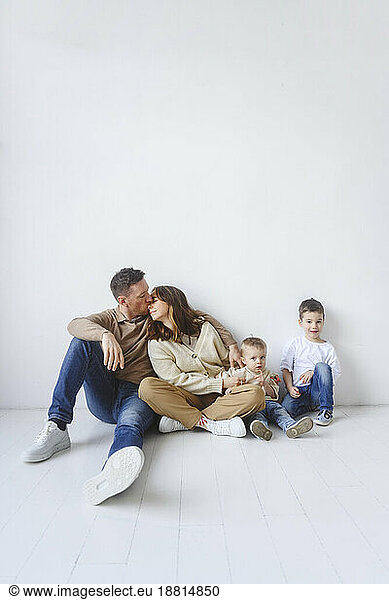 Family with two kids sitting on floor