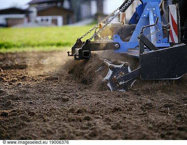 Farmer using tractor and plowing soil in field