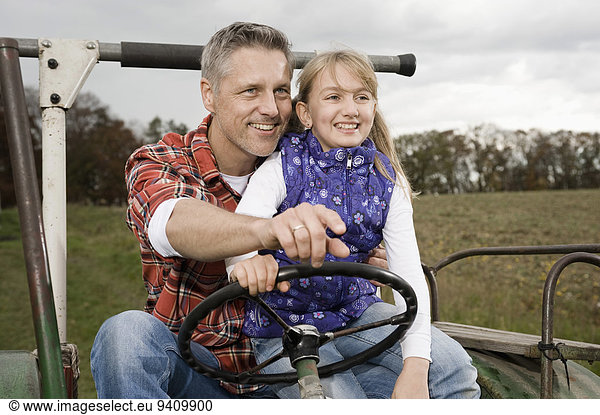 Farmer with daughter on tractor