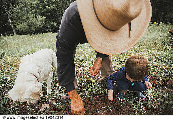 Farmer with Dog and Grandson Planting Seeds