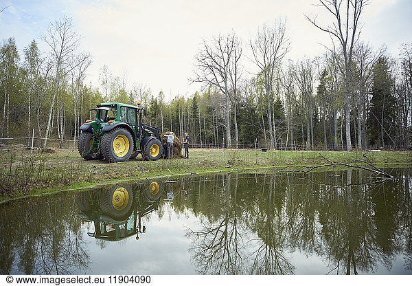 Farmers with tractor at lakeshore