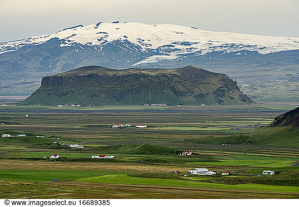 Farmhouses with snowcapped mountains in background  South Iceland