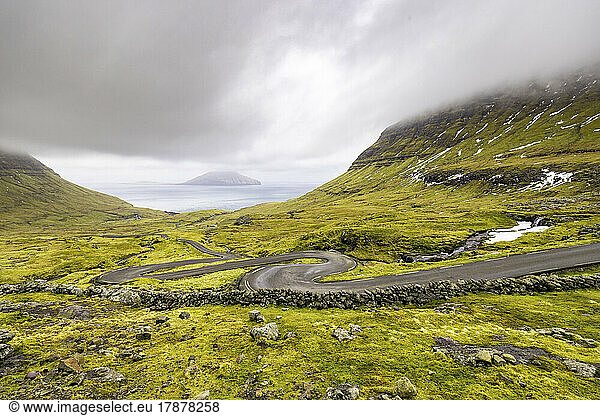 Faroe Islands  Streymoy  Cloudy sky over winding road