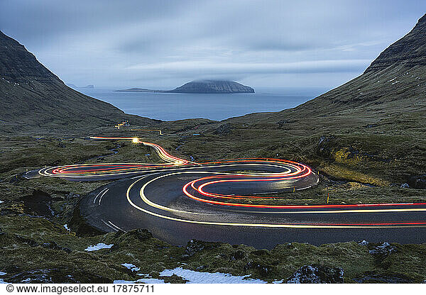 Faroe Islands  Streymoy  Vehicle light trails stretching along remote winding road