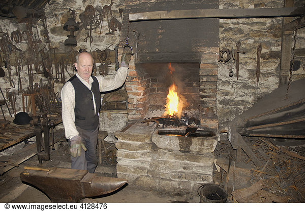 Farrier in historic workshop demonstrating his craft  Ulster American Folkpark  Omagh Co Tyrone Northern Ireland