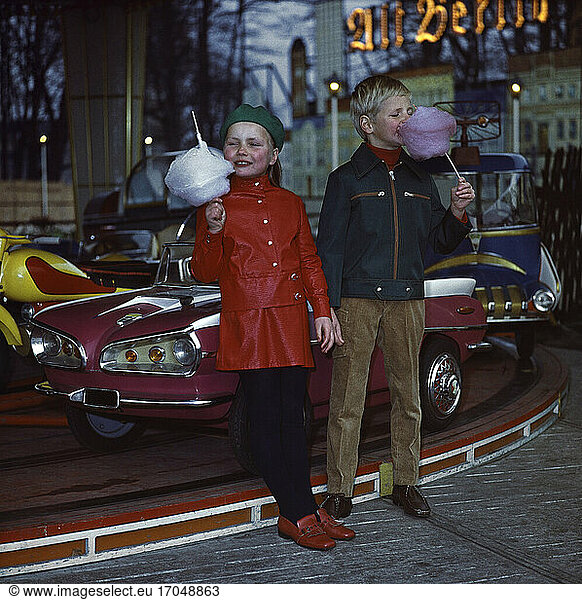 Fashion:
Children’s Fashion. Boy: jacket and corduroy trousers; girl: fake patent leather outfit (VEB Kleiderwerk Osterwieck  photographed for a catalogue for VVB– Konfektion  an East German ready-to-wear fashion manufacturer). Photo  1970.
