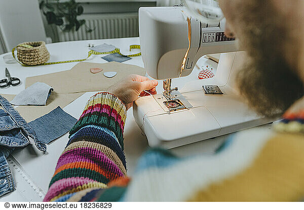 Fashion designer adjusting thread in sewing machine