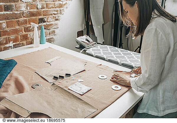 Fashion designer cutting fabric at workshop
