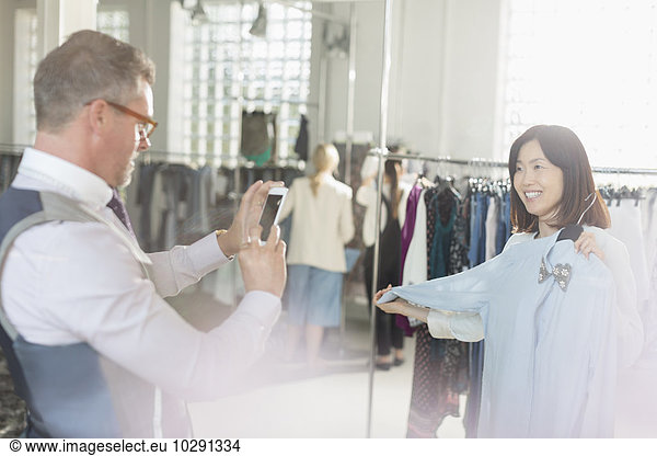 Fashion designer photographing colleague with shirt