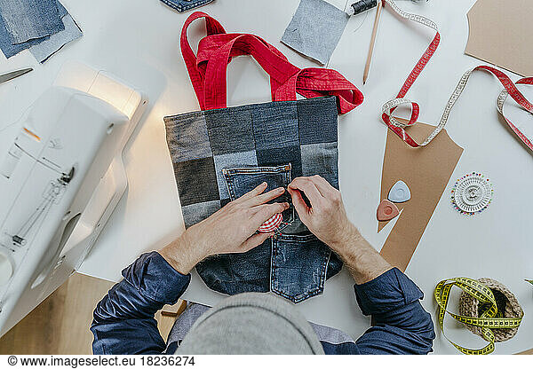 Fashion designer stitching pocket on shopping bag