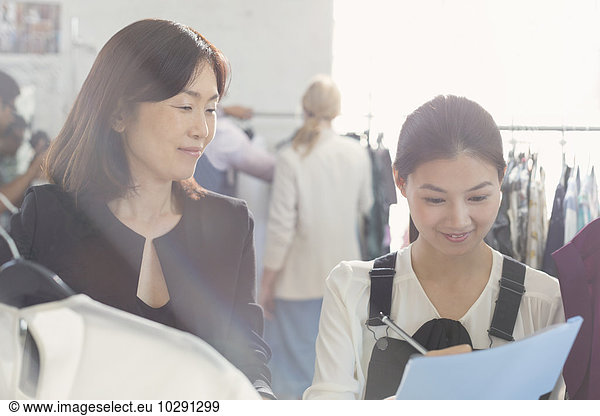 Fashion designer watching assistant taking notes