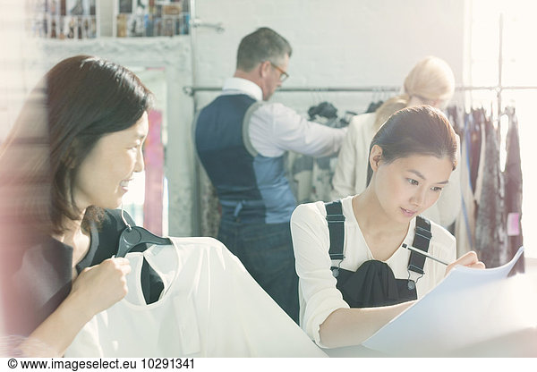 Fashion designers taking notes on clothing