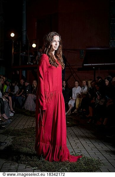 Fashion model in long wide designers dress at night show Fashion model in long wide designers dress at night show outdoor