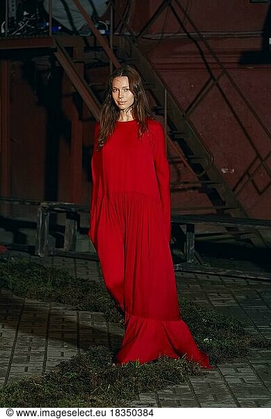Fashion model in long wide designers dress at night show outdoor