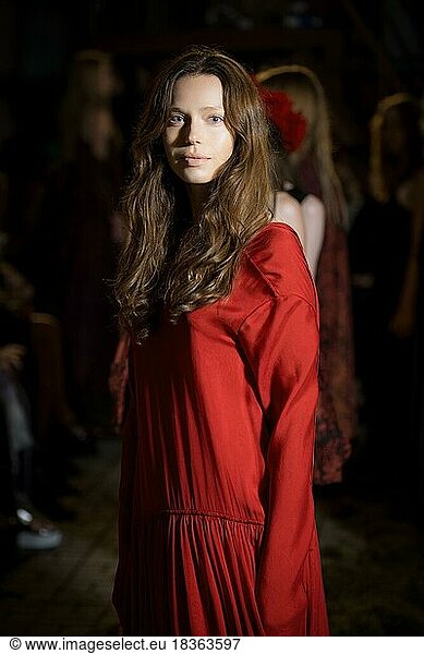 Fashion model in long wide designers dress at night show outdoor