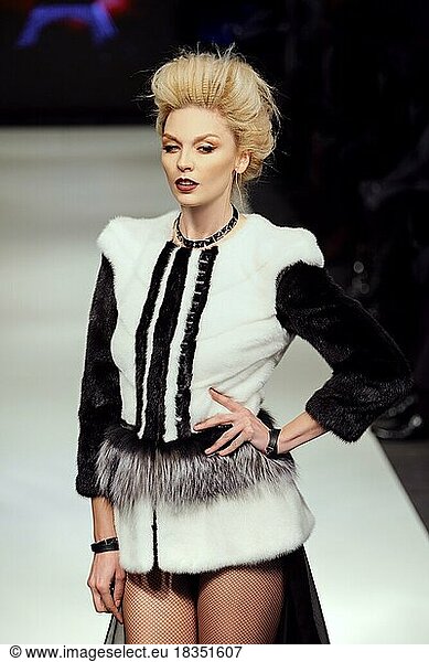 Fashion model walks on runway in fur coat at GNL show Fall-Winter 2016-2017 collection