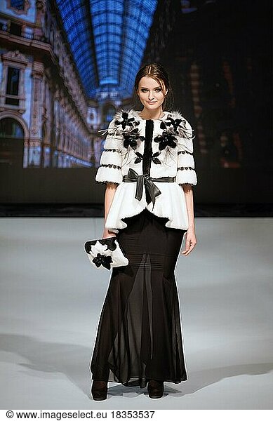 Fashion model walks on runway in fur coat during fashion show