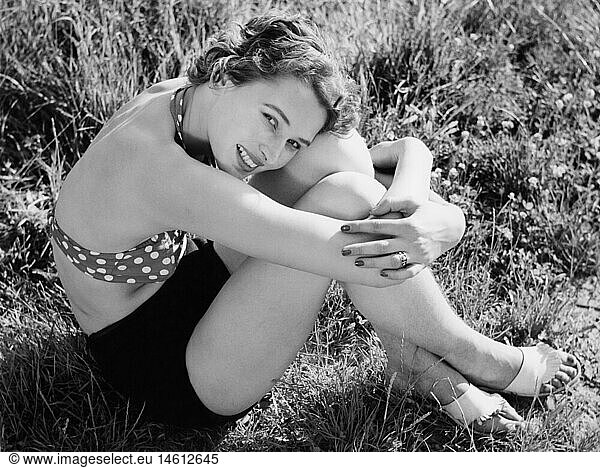 fashion  1950s  beach fashion  woman in bikini sitting on meadow  1950s
