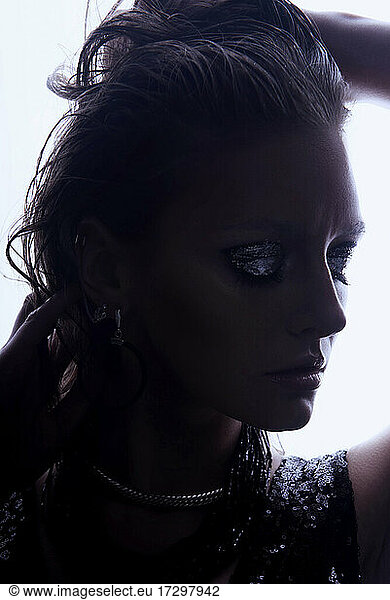 Fashion style girl portrait. Beautiful fashion woman with professional styling hairdress and makeup; dark glitter eyeshadows rock style beauty portrait