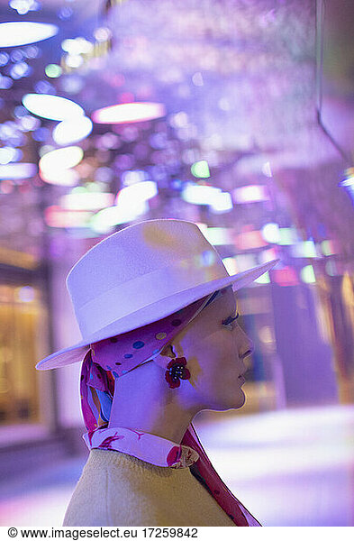Fashionable woman in fedora under neon lights
