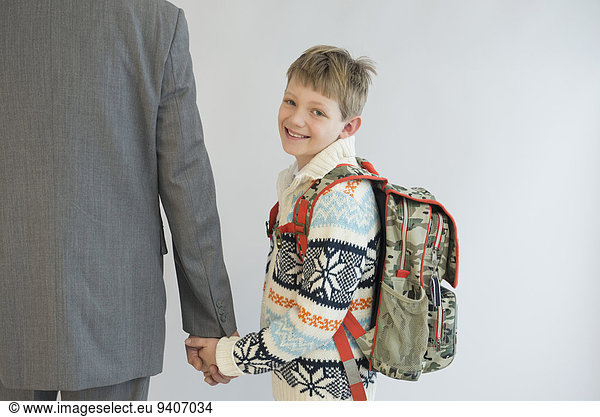 Father accompanying his son to school  smiling