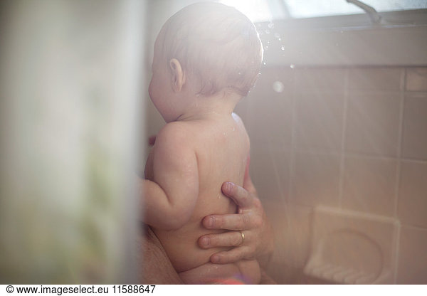 Father and baby daughter taking shower