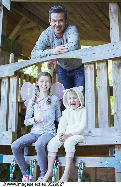 Father and children playing on playset