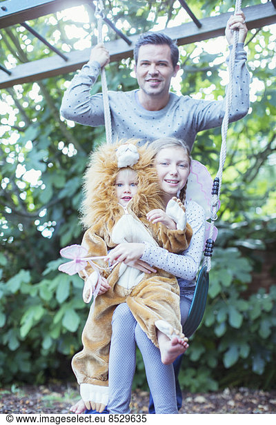 Father and children playing together on swing
