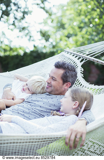 Father and children relaxing in hammock