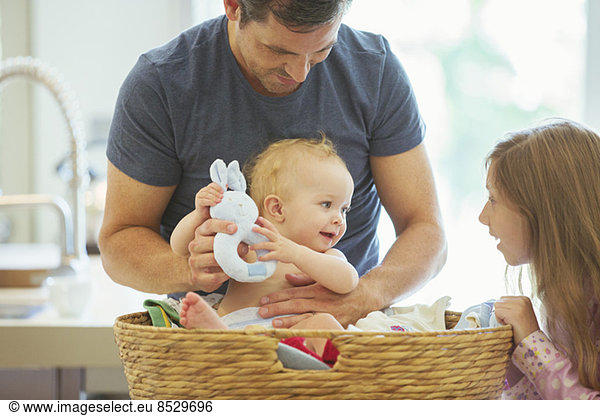 Father and children sorting laundry