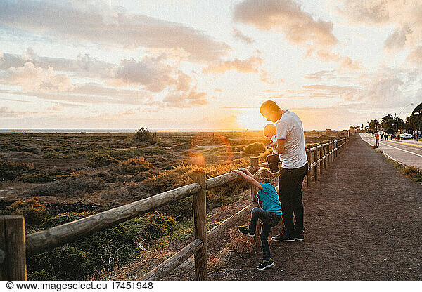 Father and children watching sunset at Fuerteventura beach