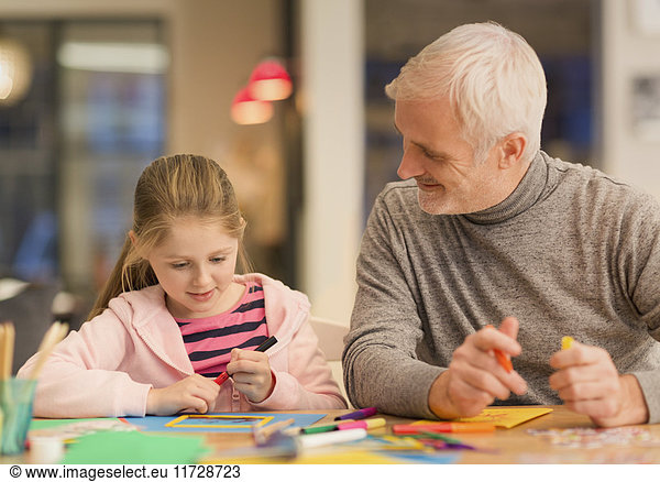 Father and daughter bonding  doing crafts at table
