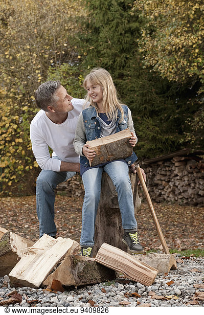 Father and daughter chopping wood