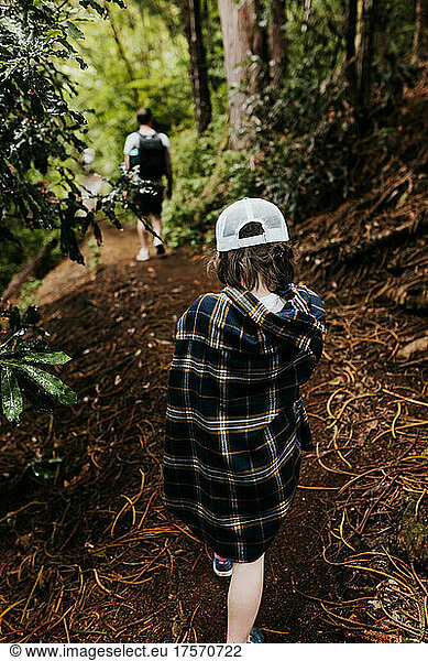 Father and daughter hike through the woods of Hawaii