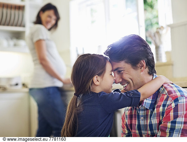 Father and daughter hugging in kitchen