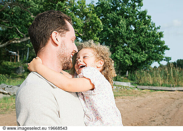 father and daughter laughing together at the beach