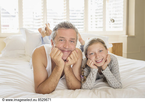 Father and daughter laying on bed