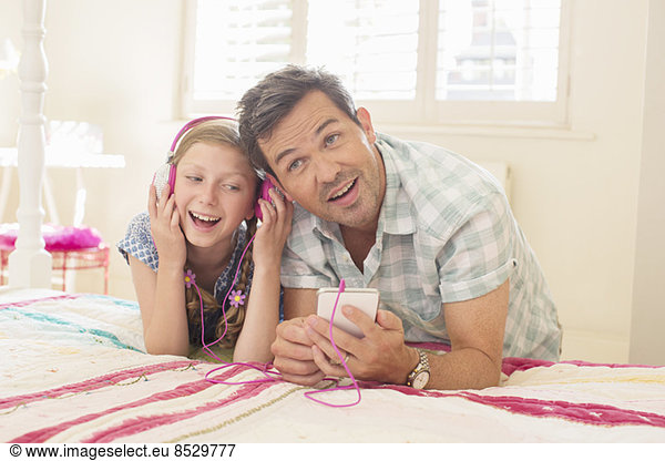 Father and daughter listening to headphones