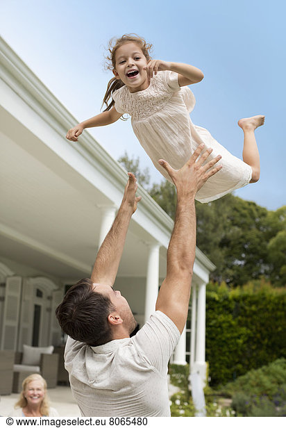 Father and daughter playing outside house