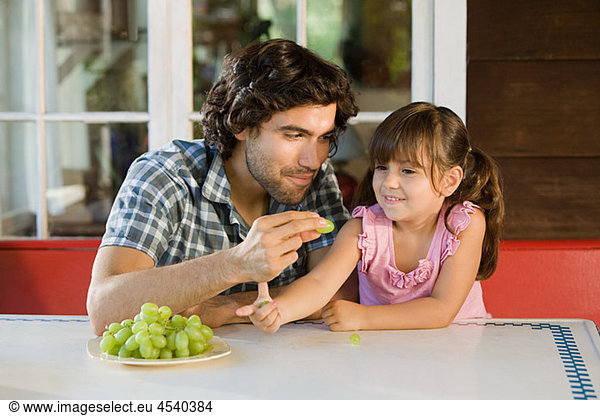 Father and daughter with grapes