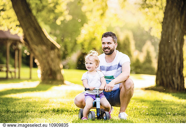 Father and his little daughter with toy car in a park