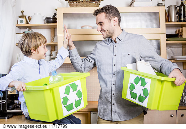 Father and son at home with waste boxes