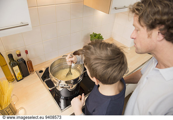 Father and son cooking spaghetti