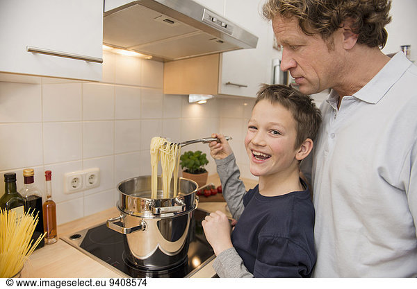 Father and son cooking spaghetti