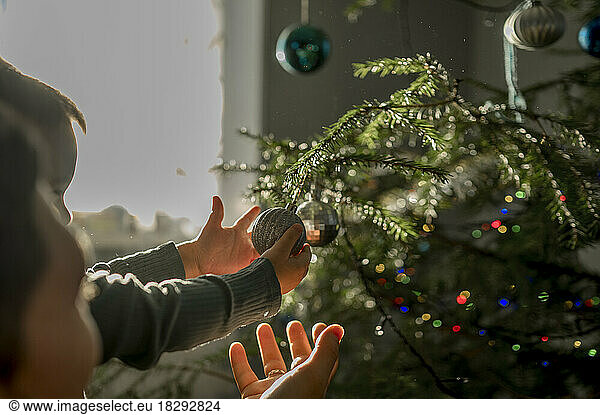 Father and son decorating Christmas tree at home