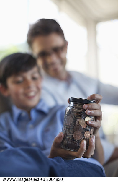 Father and son holding change jar